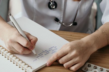 A Doctor Writing on a Notebook